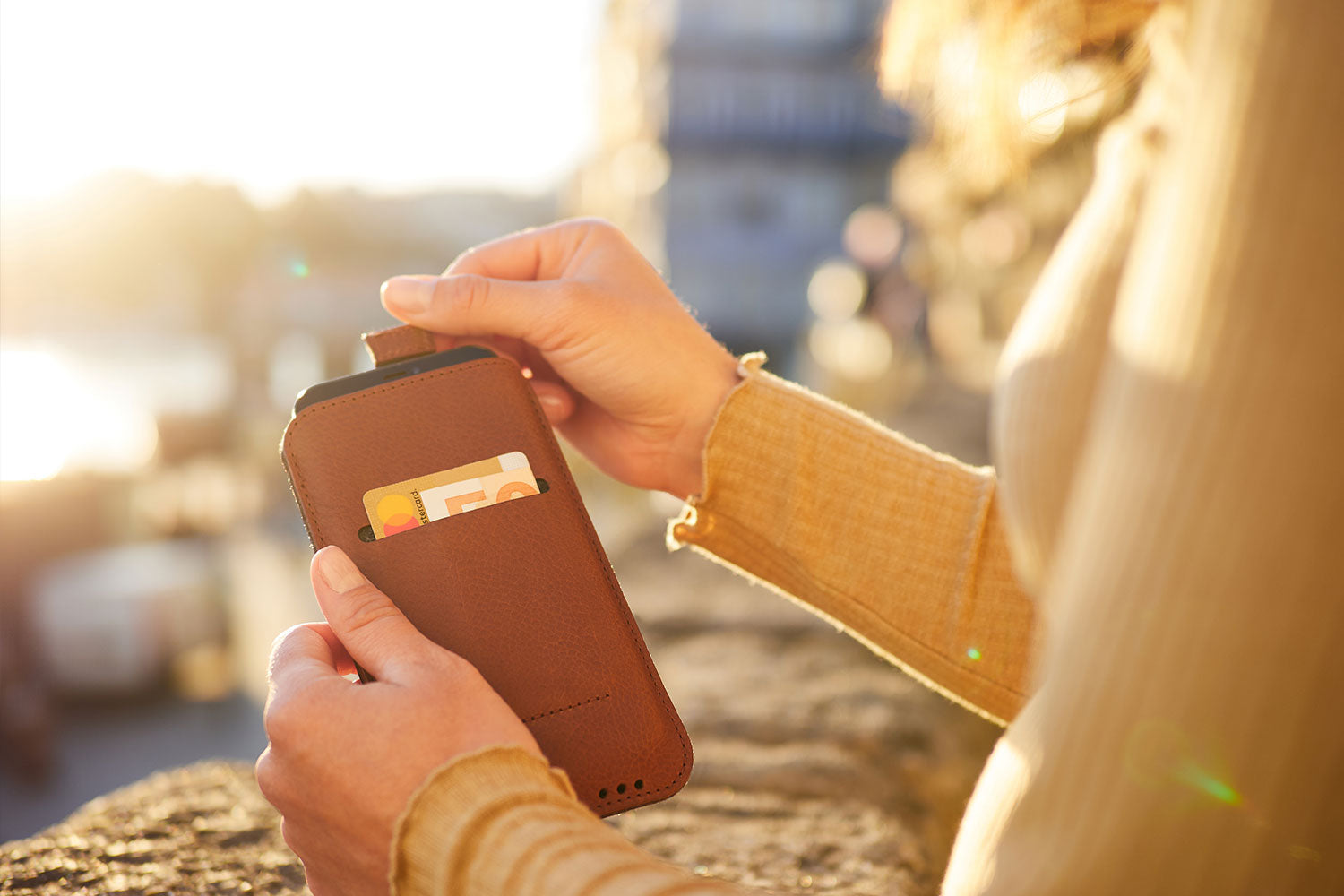 A woman holds a leather iPhone Pro 14 Max case in her hands