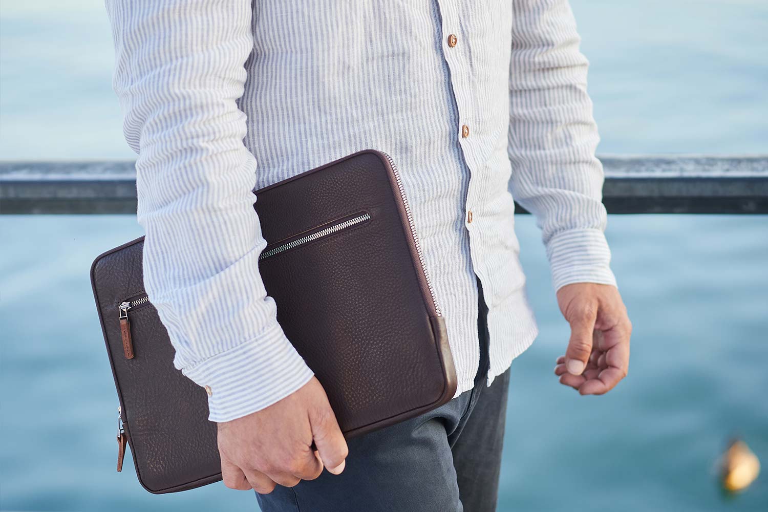 A man carries a leather iPad Pro 12.9 case under his arm