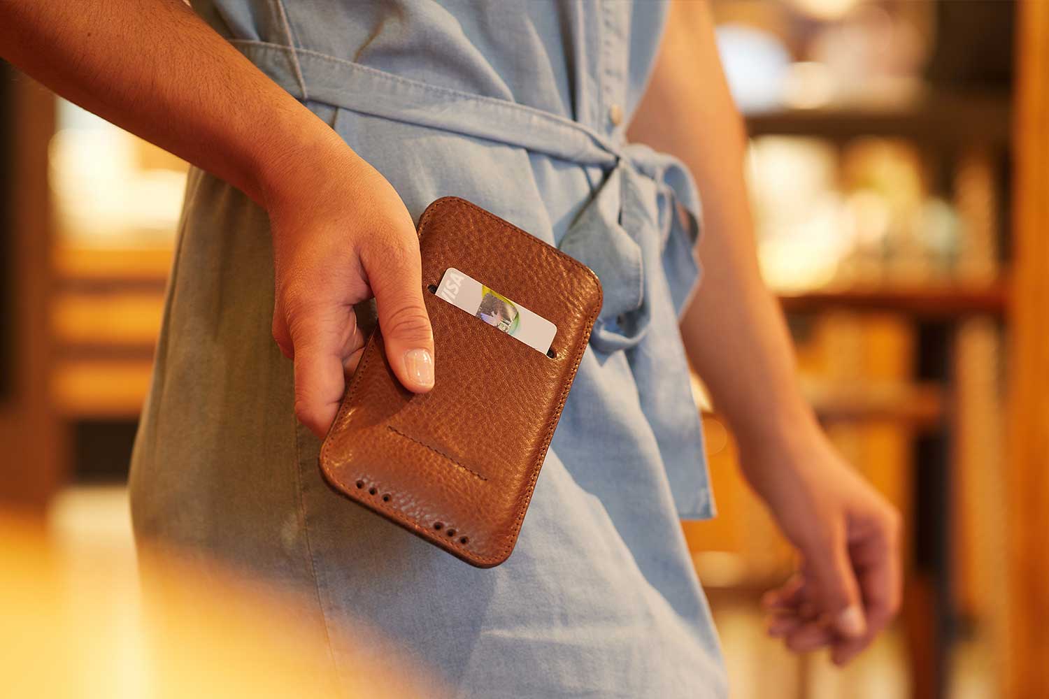 A woman holds an iPhone 12 Mini leather case in her hand