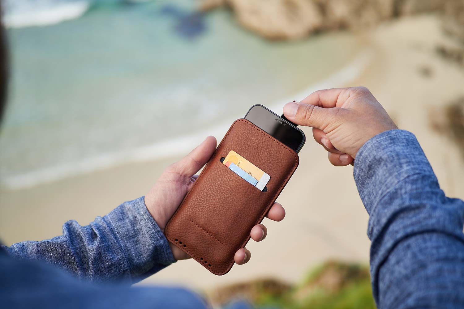 Ein Mann hält seine iPhone 14 Pro Lederhülle in den Händen und zieht an der Lasche