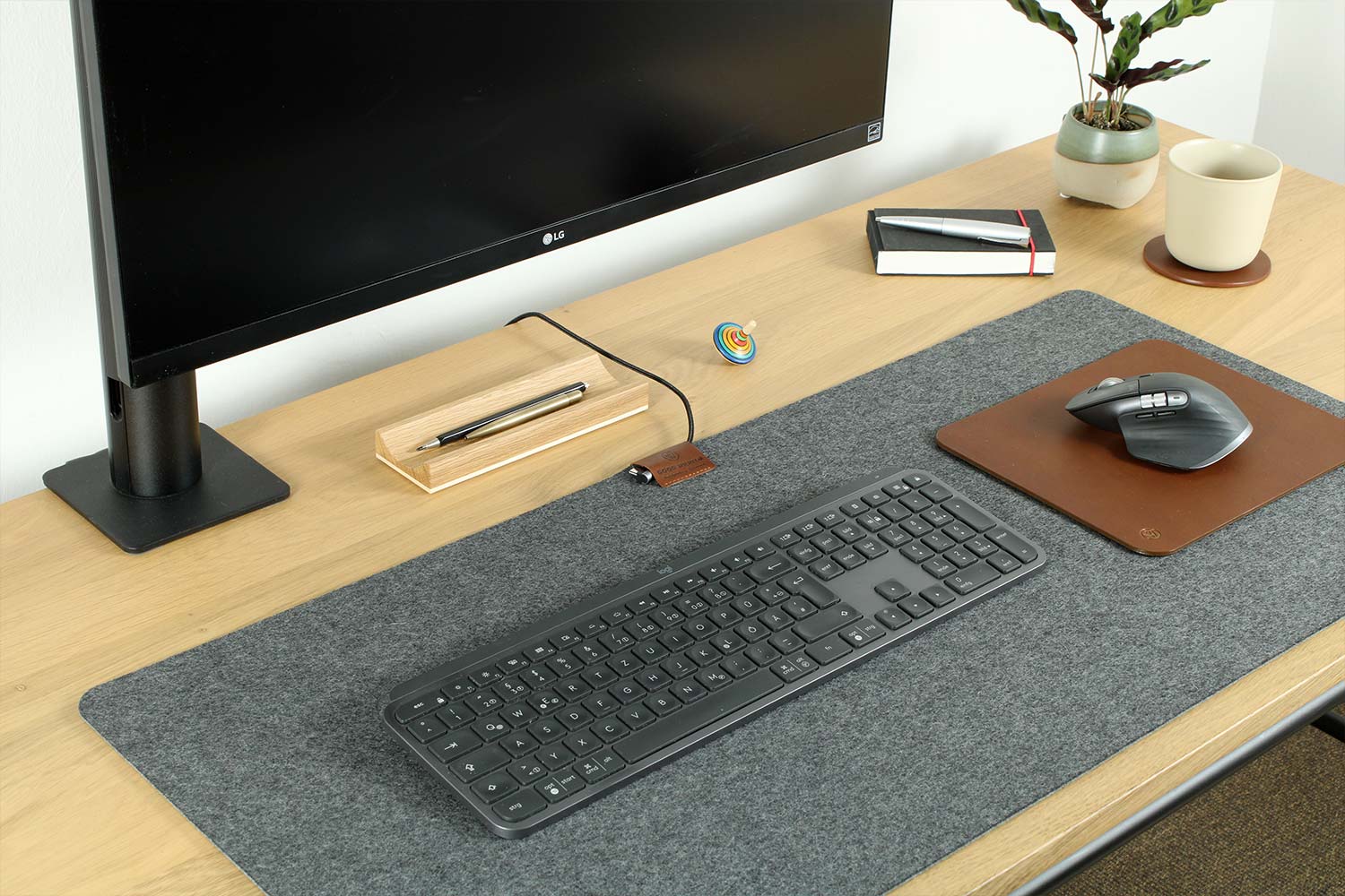 A desk pad made of wool felt and leather lies on a desk