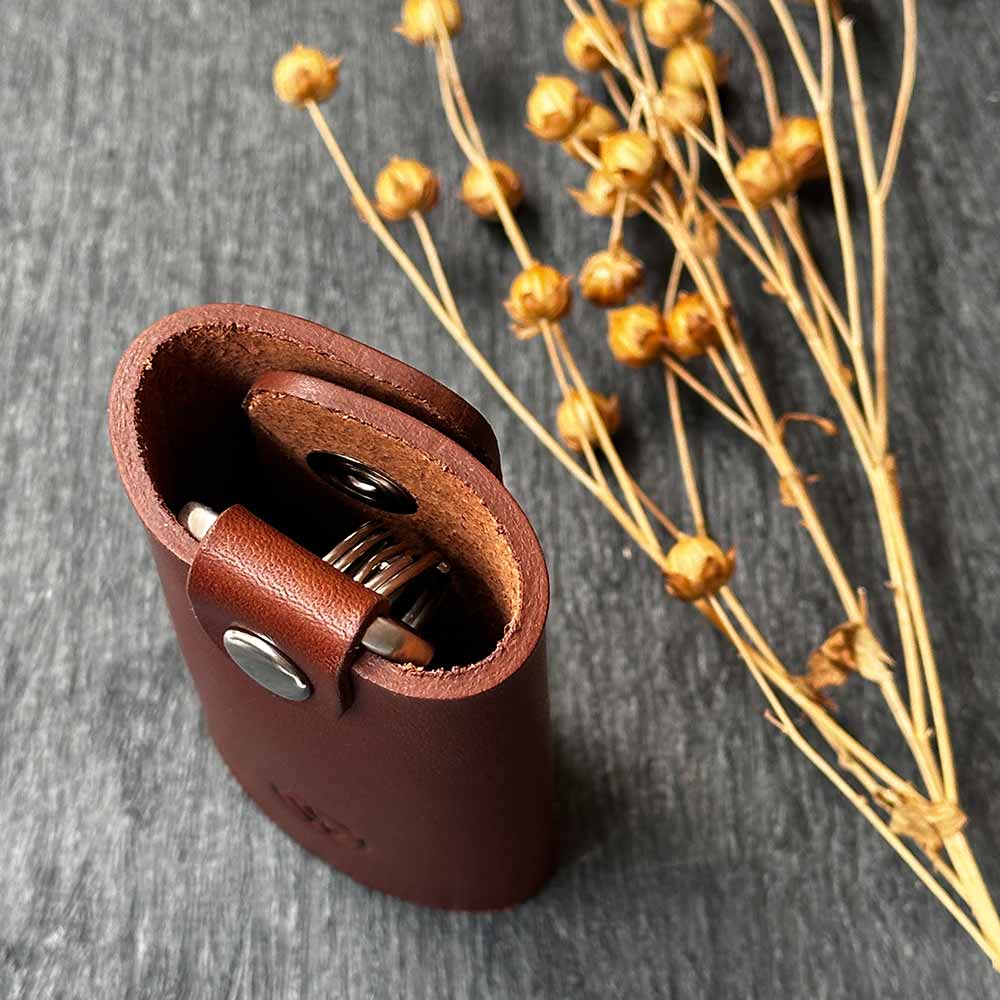 On a table is a leather key case from GoodWilhelm in light brown leather