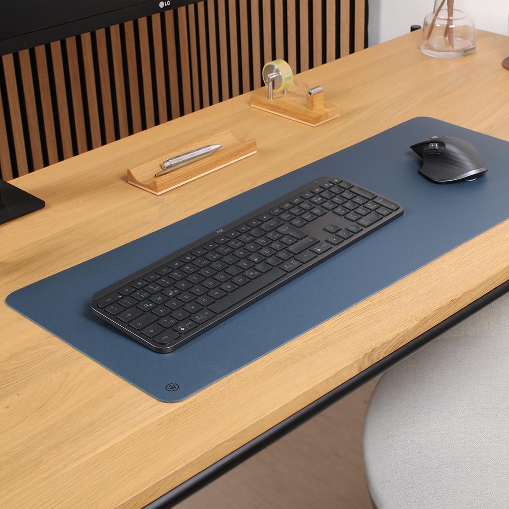 A linoleum desk pad from Good Wilhlem in blue lies on a desk table