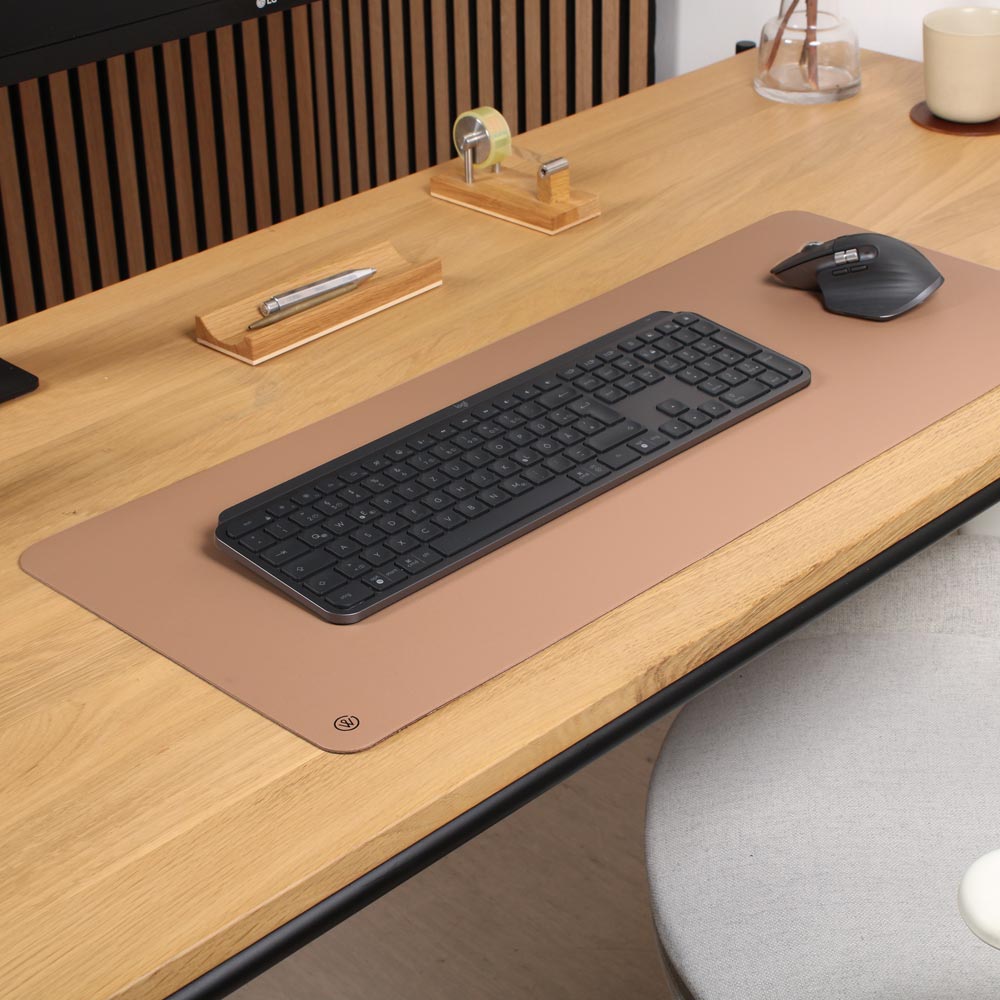 A desk pad made of linoleum in walnut from Good Wilhelm lies on a writing table