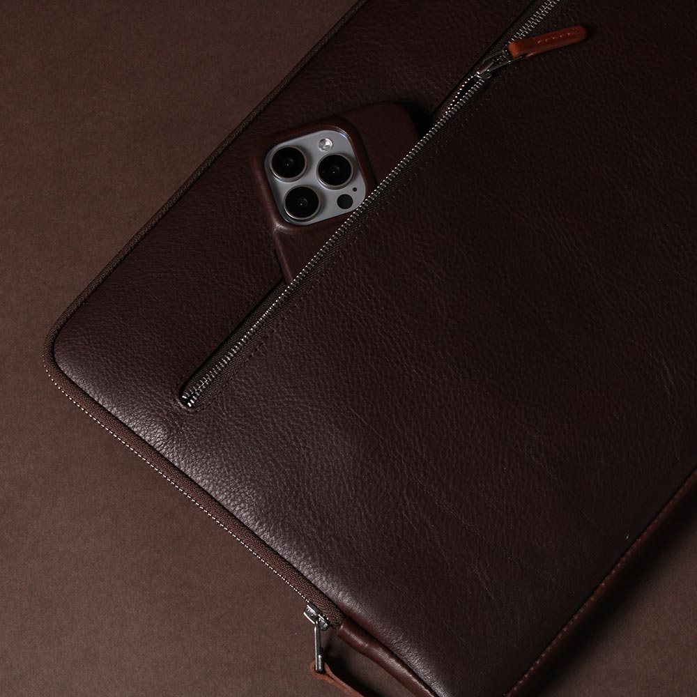 Auf einem Tisch liegt eine Macbook Hülle aus Leder in Chocolate Brown von GoodWilhelm