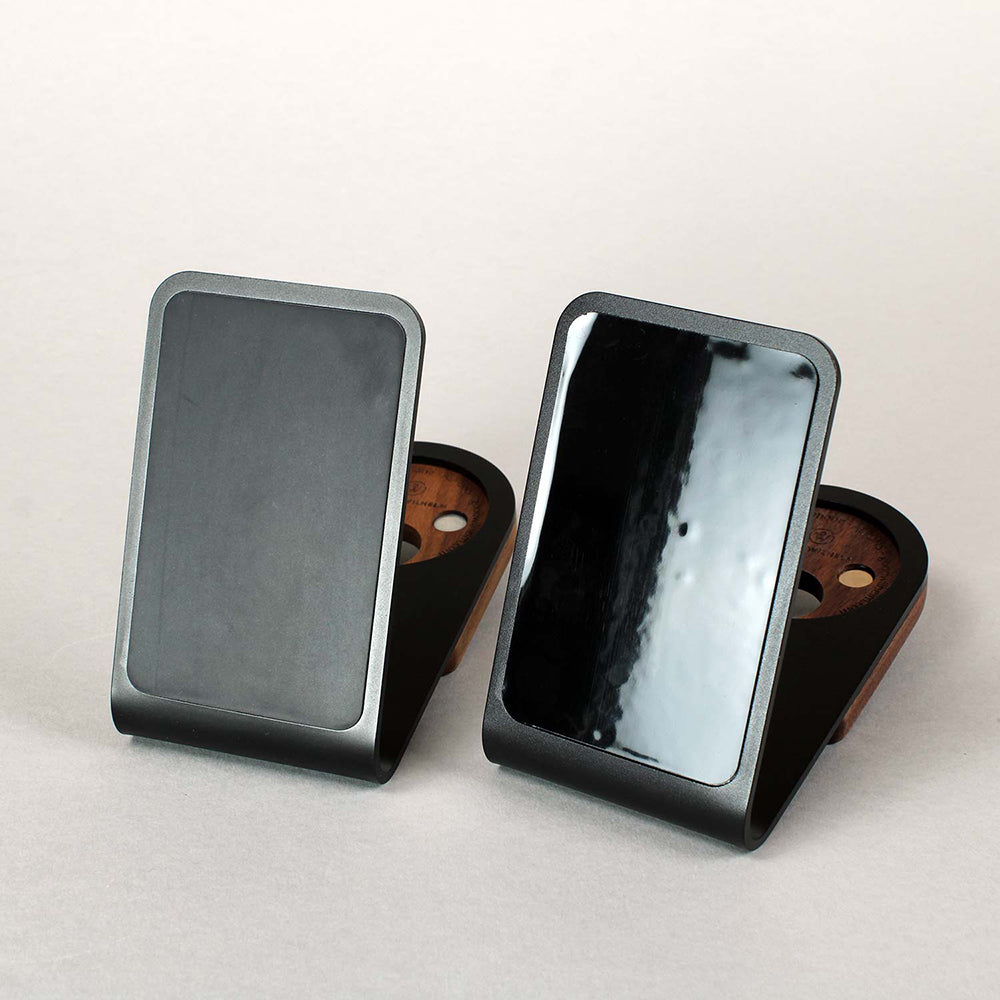 There are two aluminum Magsafe holders with anti-slip pads and suction cup foil on a table