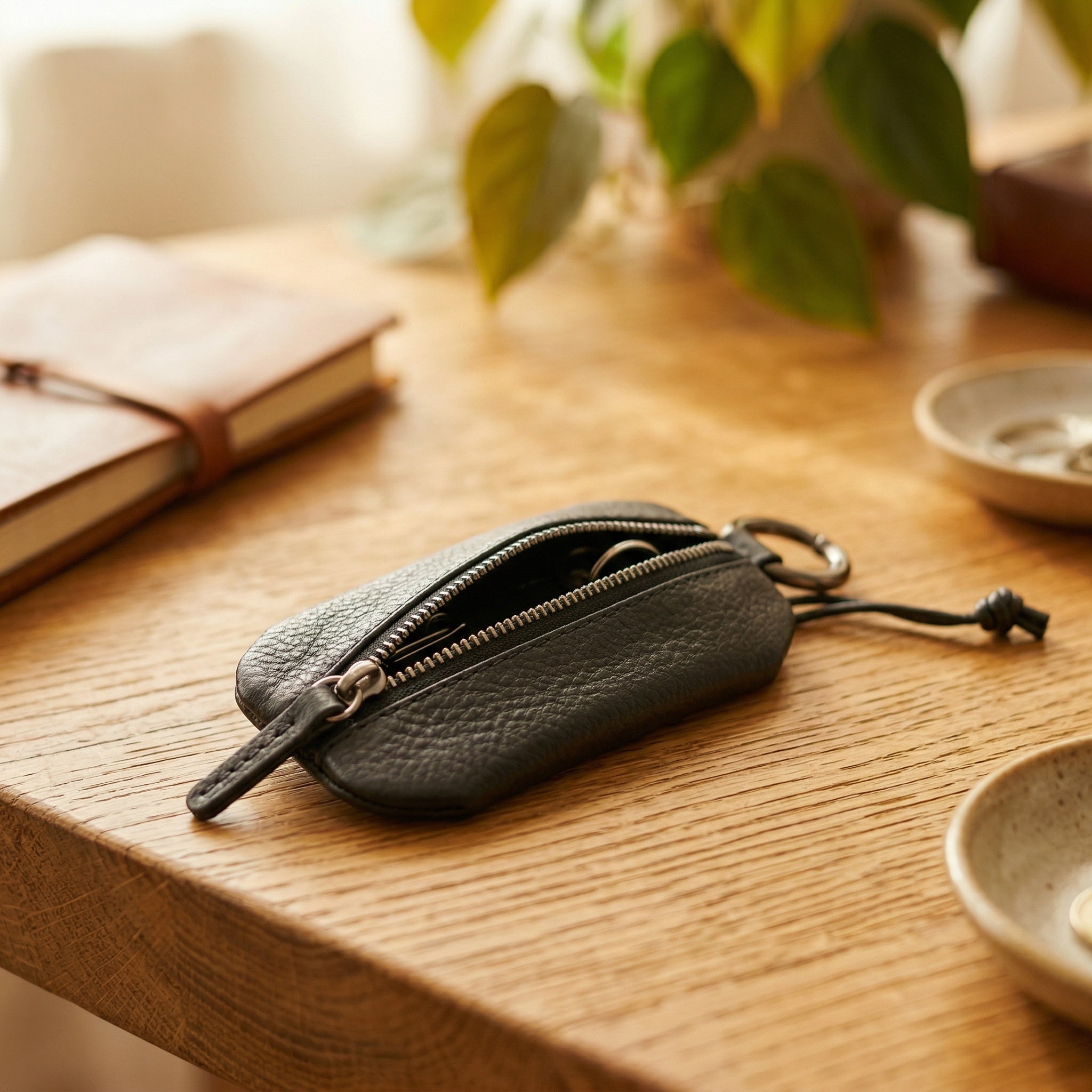 Schwarzes Schlüsseletui aus Leder von Good Wilhelm auf einem Tisch liegend mit Reißverschluss