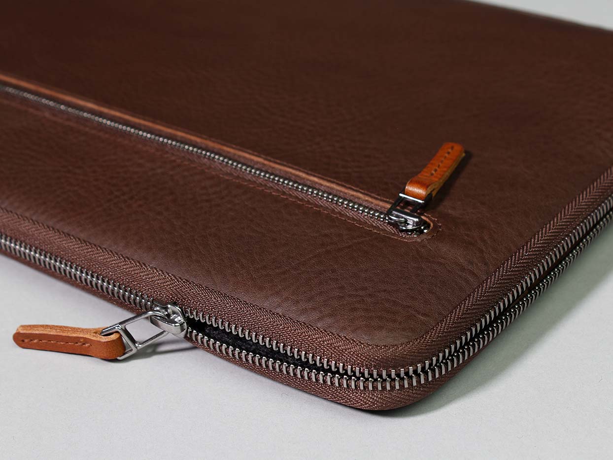 A Surface Pro case made of dark brown leather lies on a table