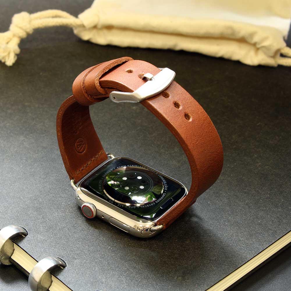 Auf einem Tisch liegt eine Apple Watch mit Lederarmband in Cognac von Goodwilhelm