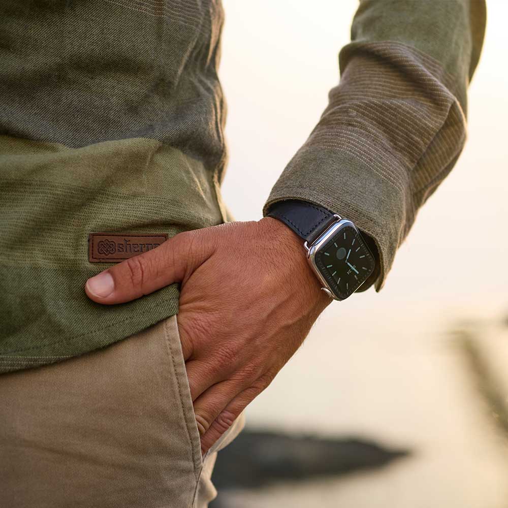 Man has put his hand in his trouser pocket and on his wrist he is wearing an Apple Watch with a leather strap from Goodwilhelm