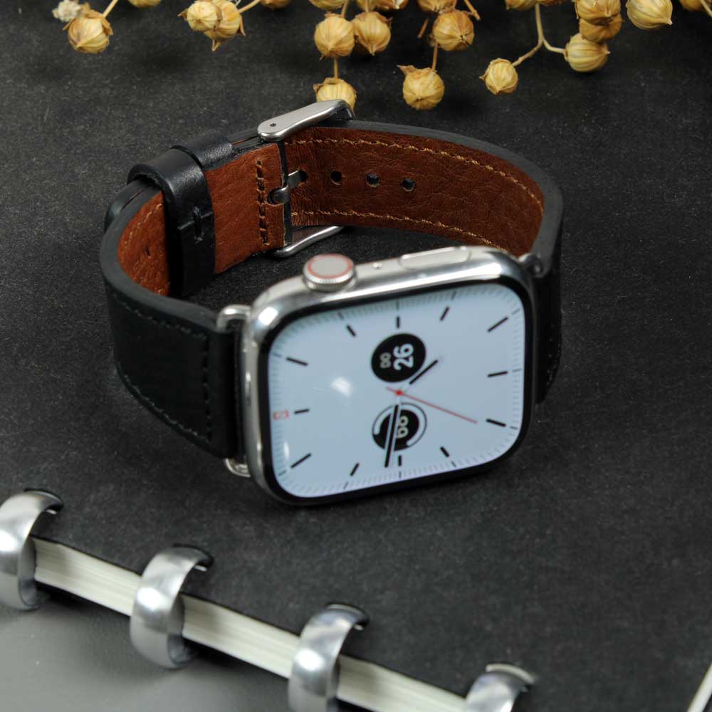 On a table is a watch with a black leather strap from Goodwilhelm