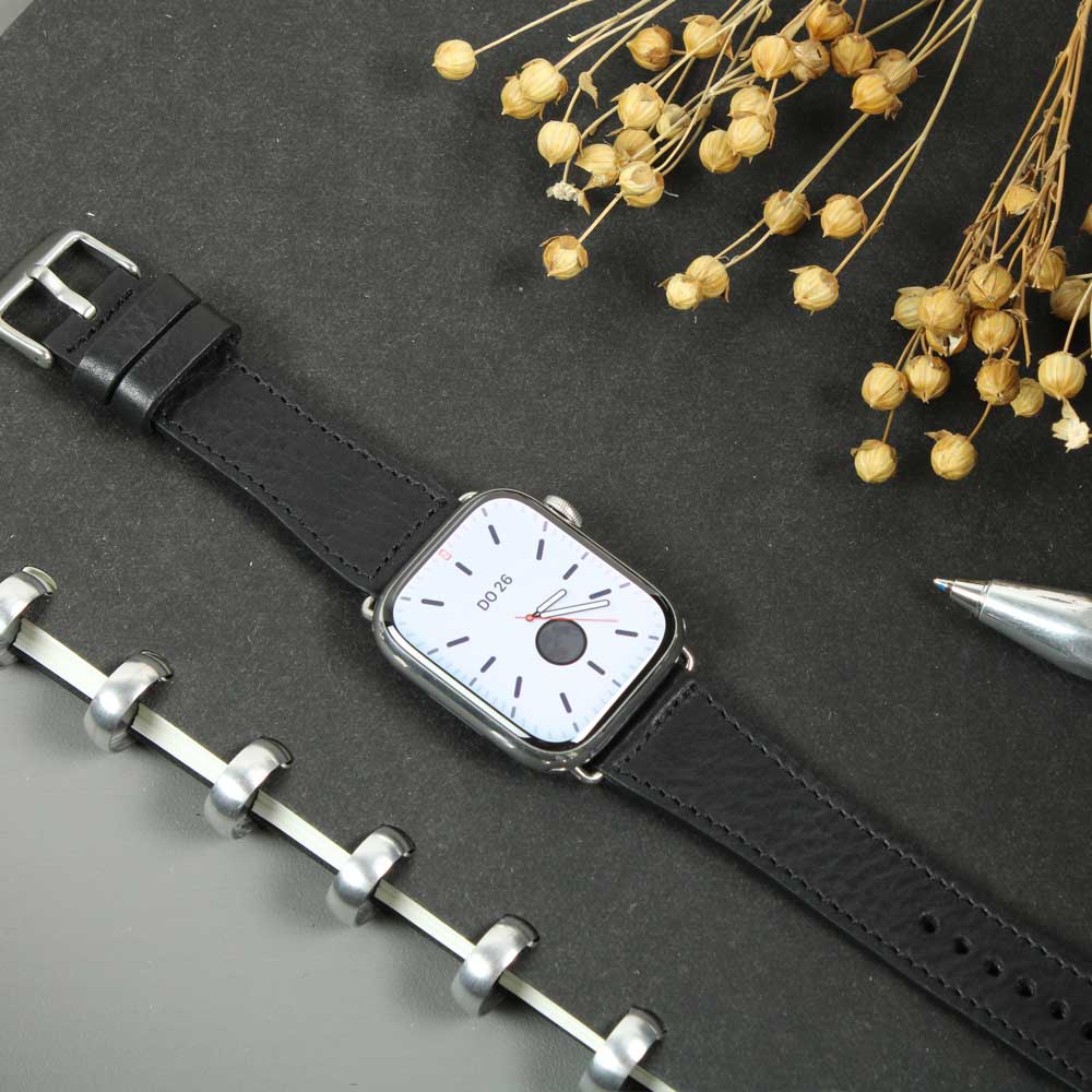 On a table lies a watch with a black leather strap from Goodwilhelm