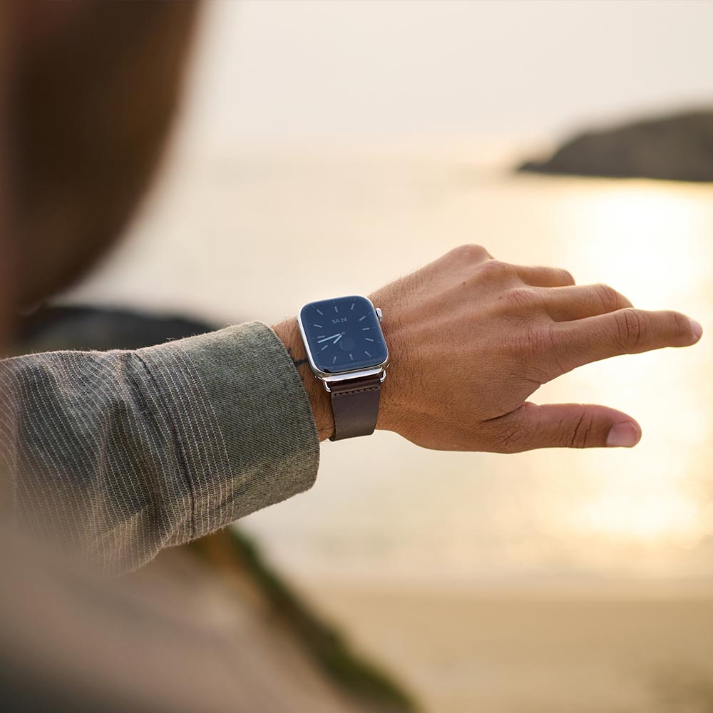 Ein Mann schaut auf seine Uhr mit Lederarmband von goodwilhelm