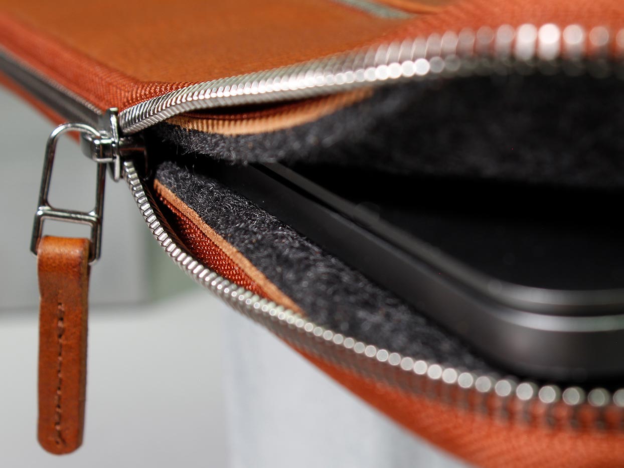 A laptop peeks out of a leather sleeve