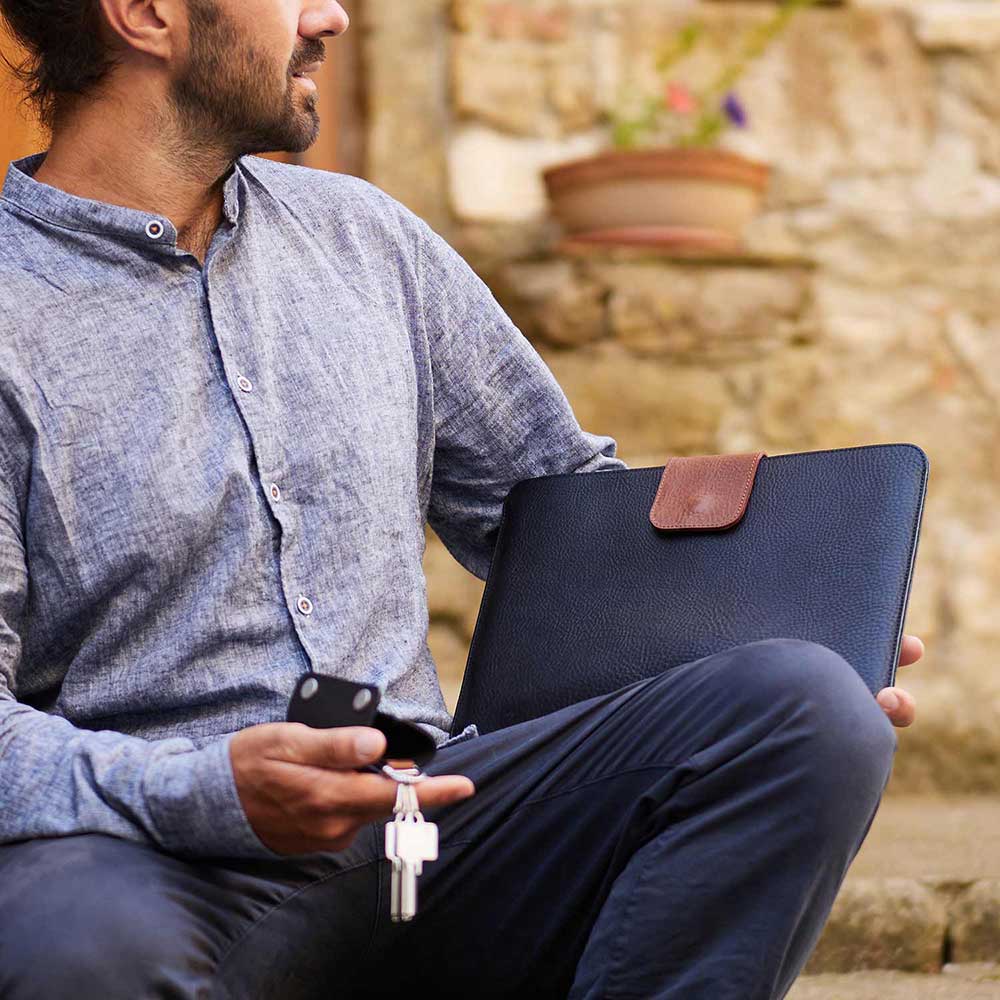 Ein Mann hält eine Macbook Hülle von Goodwilhelm in der Farbe Schwarz in den Händen