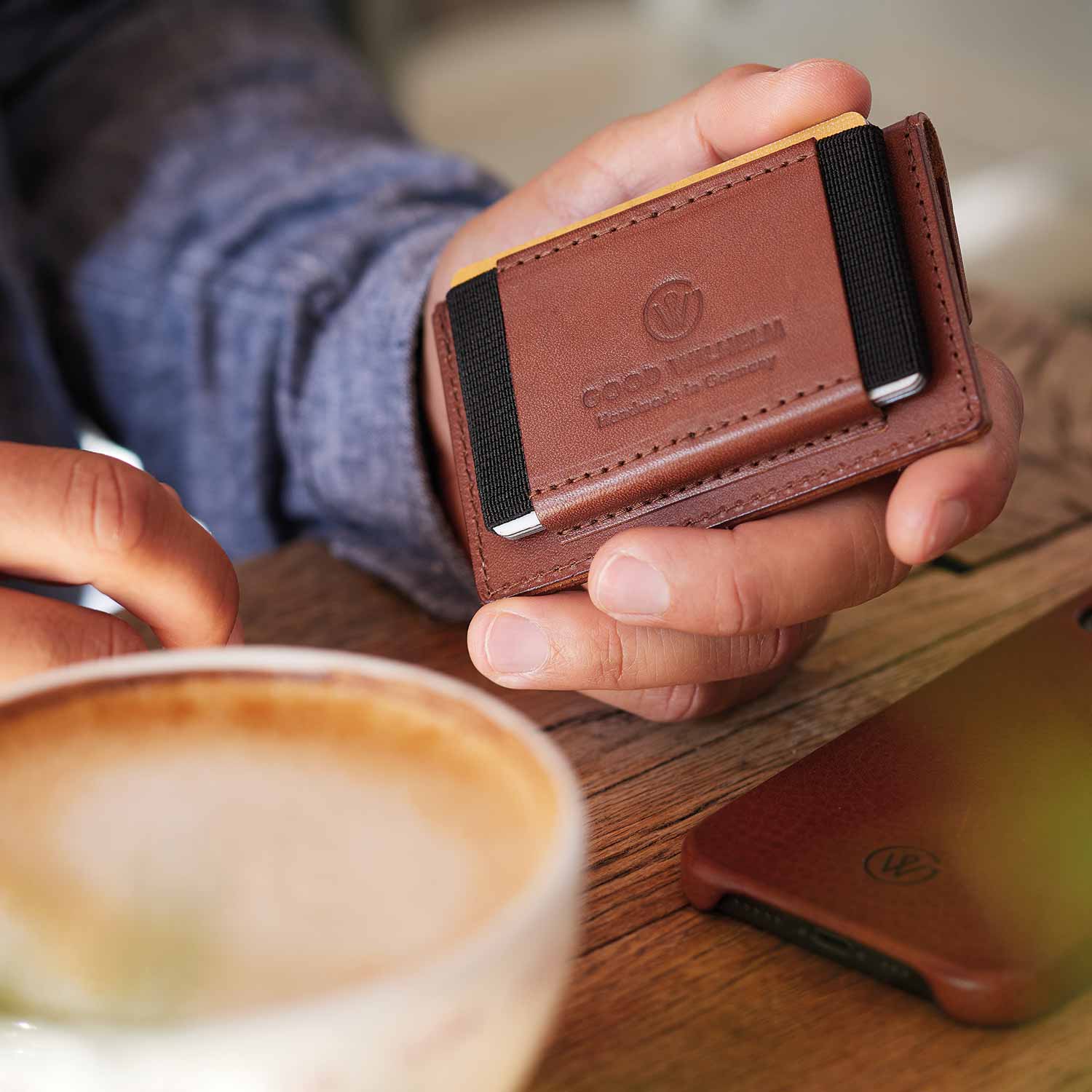 Hand holding mini wallet OTTO from Goodwilhelm in the color cognac