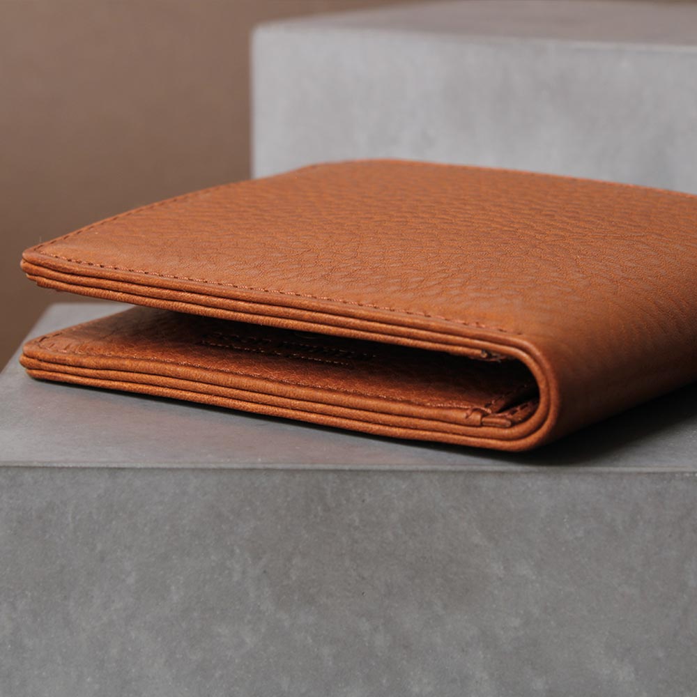 Cognac brown men's wallet in side view, high-quality workmanship, on a concrete base - Good Wilhelm brand