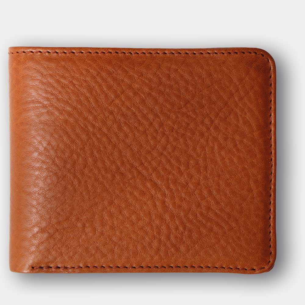 Closed wallet made from vegetable-tanned leather in cognac brown on a white background