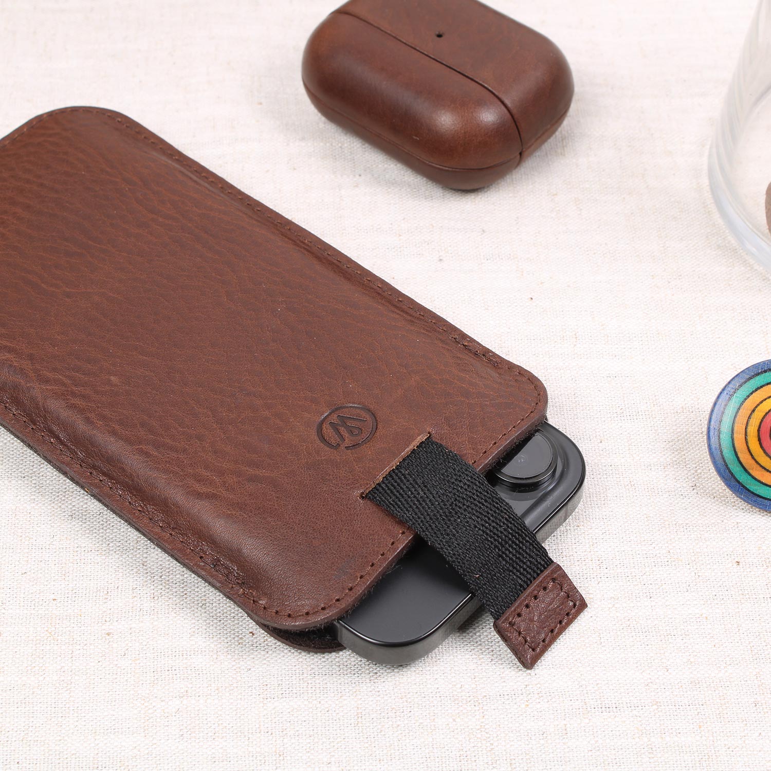 Edle iPhone Leder Hülle in Chocolate Braun mit Ziehhilfe – hochwertiges pflanzlich gegerbtes iPhone Sleeve von Good Wilhelm in stilvoller Umgebung.