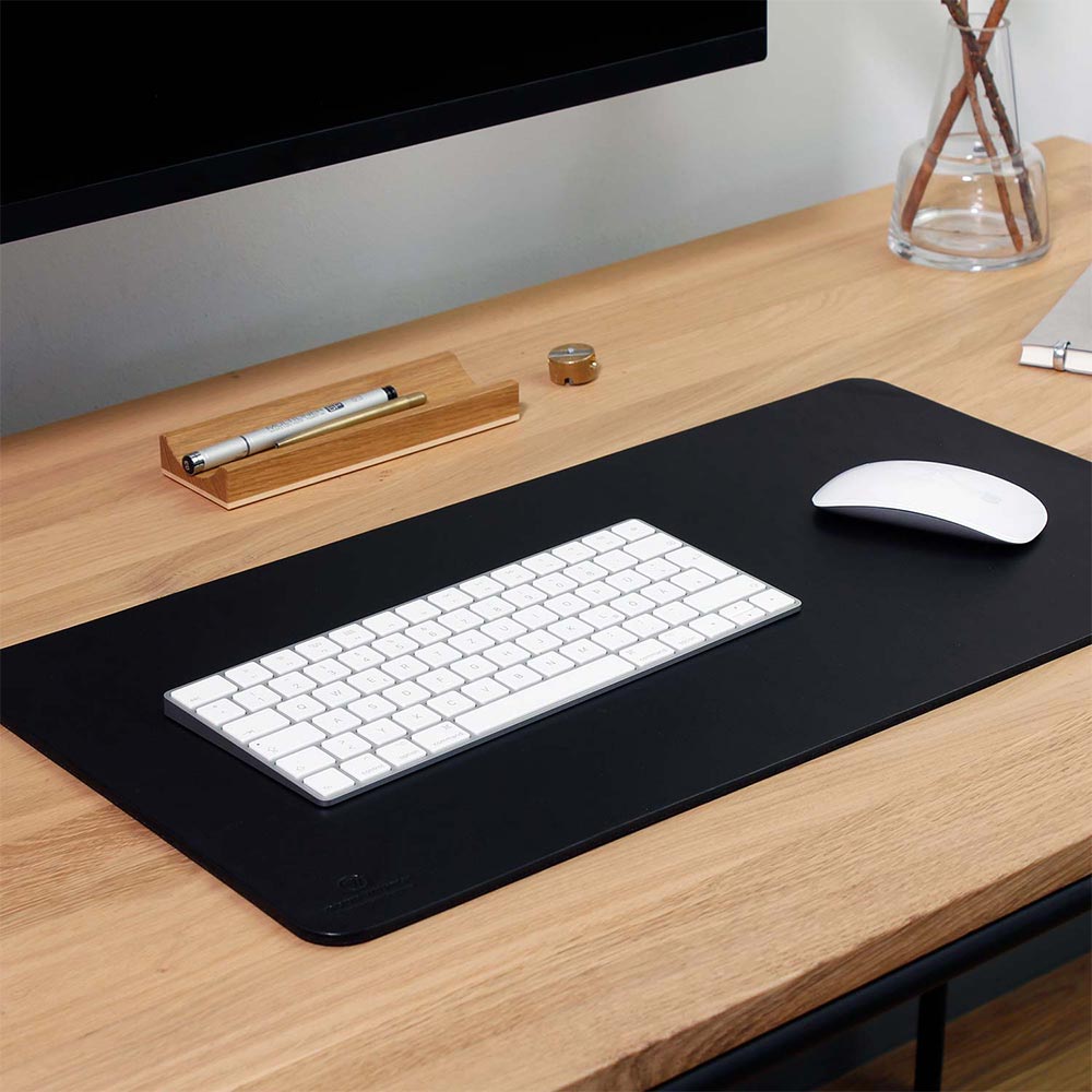 Tastatur und Computermaus liegen auf Schreibtischunterlage KARL in der Farbe black von Goodwilhelm
