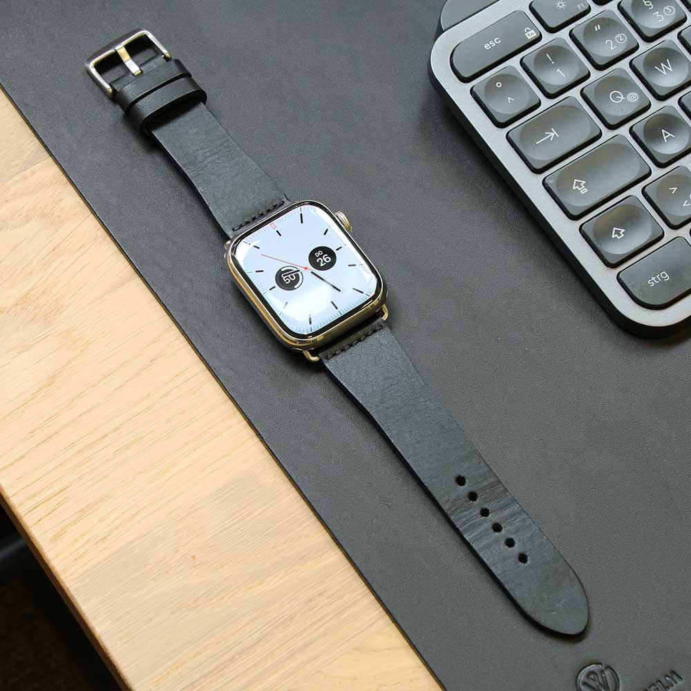Auf einem Tisch liegt eine Apple Watch mit Lederarmband in der Farbe Black von Goodwilhelm