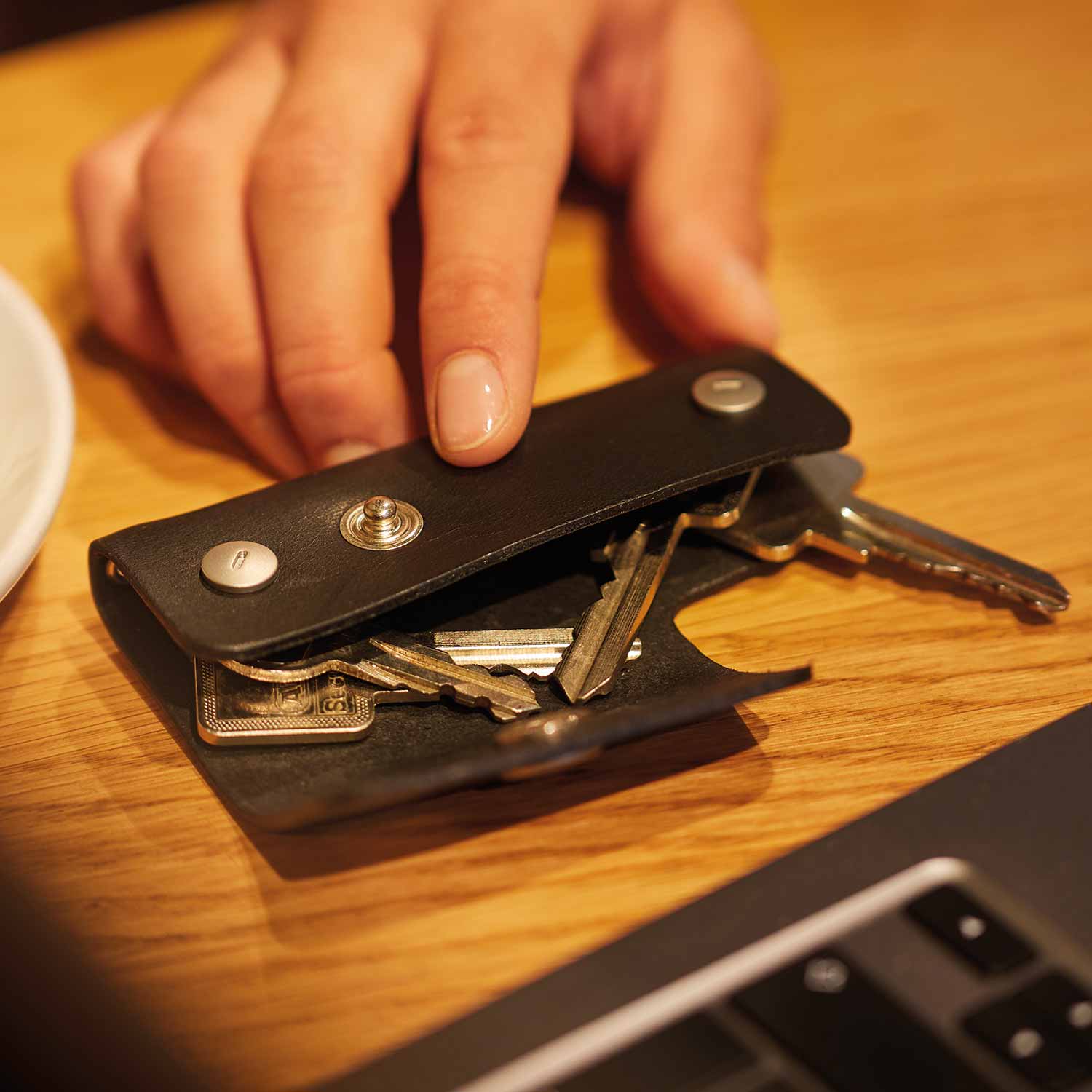Schlüsseletui EMIL von Goodwilhelm in der Farbe black liegt mit Schlüsseln auf einem Tisch